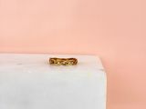 une bague en or posée sur un bloc de marbre blanc