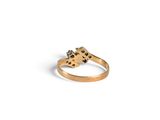 a close up of a gold ring with black diamonds on a white background
