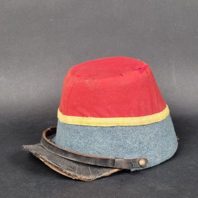 un bonnet rouge et bleu orné d'un ruban jaune