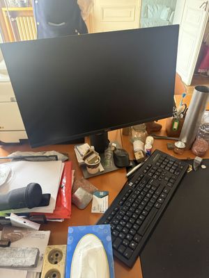 a desk with a computer, keyboard, mouse, and other items on it