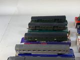 several model trains are lined up in a row on a white surface