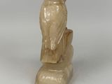 a statue of an owl sitting on top of a tree stump