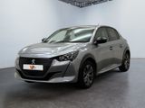 une voiture argentée garée dans une pièce blanche au sol noir