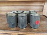 six glasses are lined up on a wooden shelf in a room