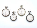 quatre montres de poche anciennes posées sur une surface blanche