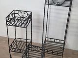 three black metal plant stands on a wooden floor next to a white wall