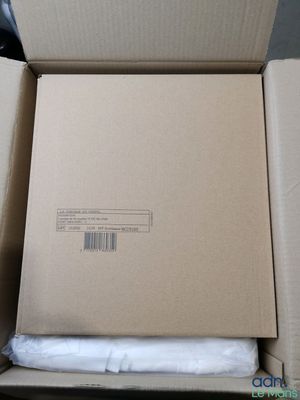 une boîte ouverte contenant un drap blanc, posée sur une table