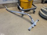 a yellow drum on a dolly with a hose on the floor