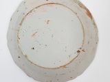 a white plate with a brown rim sitting on a table
