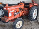 a red tractor that is parked in a barn