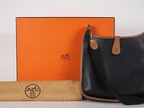 an image of a black and tan handbag and an orange box