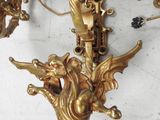 quatre appliques dorées posées sur une table blanche