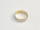 gros plan d'une bague en or sur une surface blanche