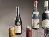 several bottles of wine sit on a clear shelf next to a can of soda