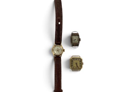 une montre et deux petites montres posées sur une surface blanche