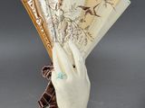 a white hand holding a fan on a table