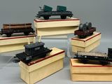 cinq types différents de petits trains exposés sur une table