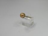 a close up of a gold pearl on a clear stand