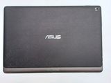 the back of a black asus tablet computer sitting on top of a white table