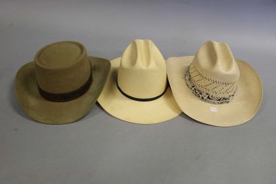 three hats are lined up on a table with a white background