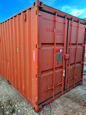 a red shipping container sitting on the side of the road