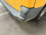a close up of a yellow truck parked in a parking lot