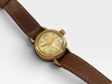 un gros plan d'une montre montée sur un bracelet en cuir marron