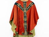 an orange and green robe hanging on a hanger on a white wall