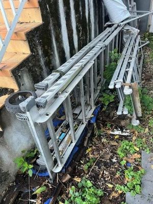 une échelle appuyée contre un mur, à côté d'un escalier