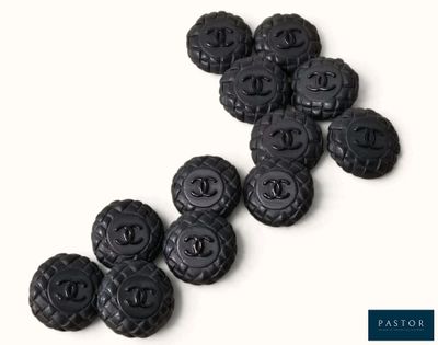 de nombreux boutons en plastique noir sur une surface blanche