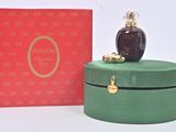 a bottle of perfume sitting on top of a green box