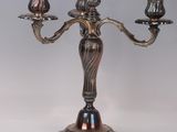 a silver plated candelab with three candles on a stand