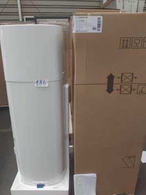 un réfrigérateur blanc posé à côté d'un carton posé par terre