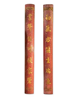 pair of red and gold painted wooden poles with asian writing