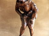 wooden figurine of a man holding a baseball bat on a wooden base