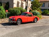une voiture rouge garée devant un bâtiment