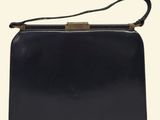 a black purse with a gold clasp on the handle