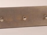 a close up of a metal plaque with three knobs on it