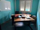 a desk with a chair and a white board in the corner