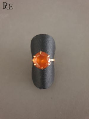 une image d'une bague sertie d'une pierre orange