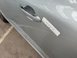 a silver car with a sticker on the door handle