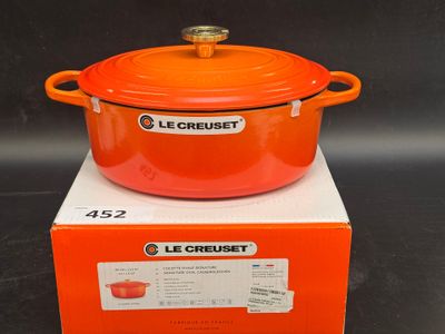 une cocotte Le Creuset orange posée sur une boîte
