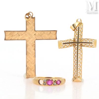 two gold crosses and a pink stone ring on a white surface