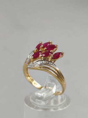 a close up of a gold ring with red stones on it