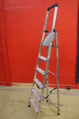a ladder that is leaning against a red wall