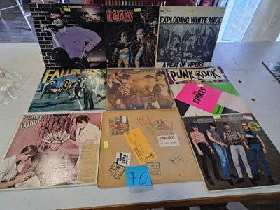 plein de disques posés sur une table, avec un verre de vin