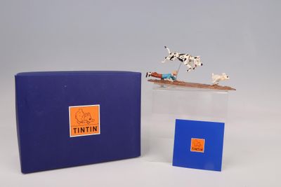 une petite figurine représentant un chien posée sur une boîte