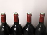 three bottles of wine are lined up on a wooden table