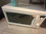 a bottle of water sitting on top of a microwave oven
