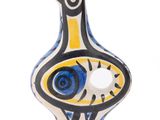 un vase en céramique orné d'un oiseau bleu et jaune
